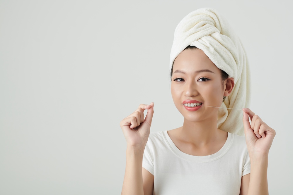 a woman flossing her teeth